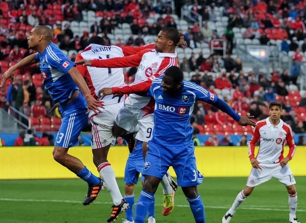 Toronto FC's Ryan Johnson (centre) wins the battle for a header against teammate Doneil Henry and Montreal Impact's Matteo Ferrari (left) and Shavar Thomas (right). TFC won 2-0 against the Impact on Wednesday night at BMO Field (Karan Vyas)
